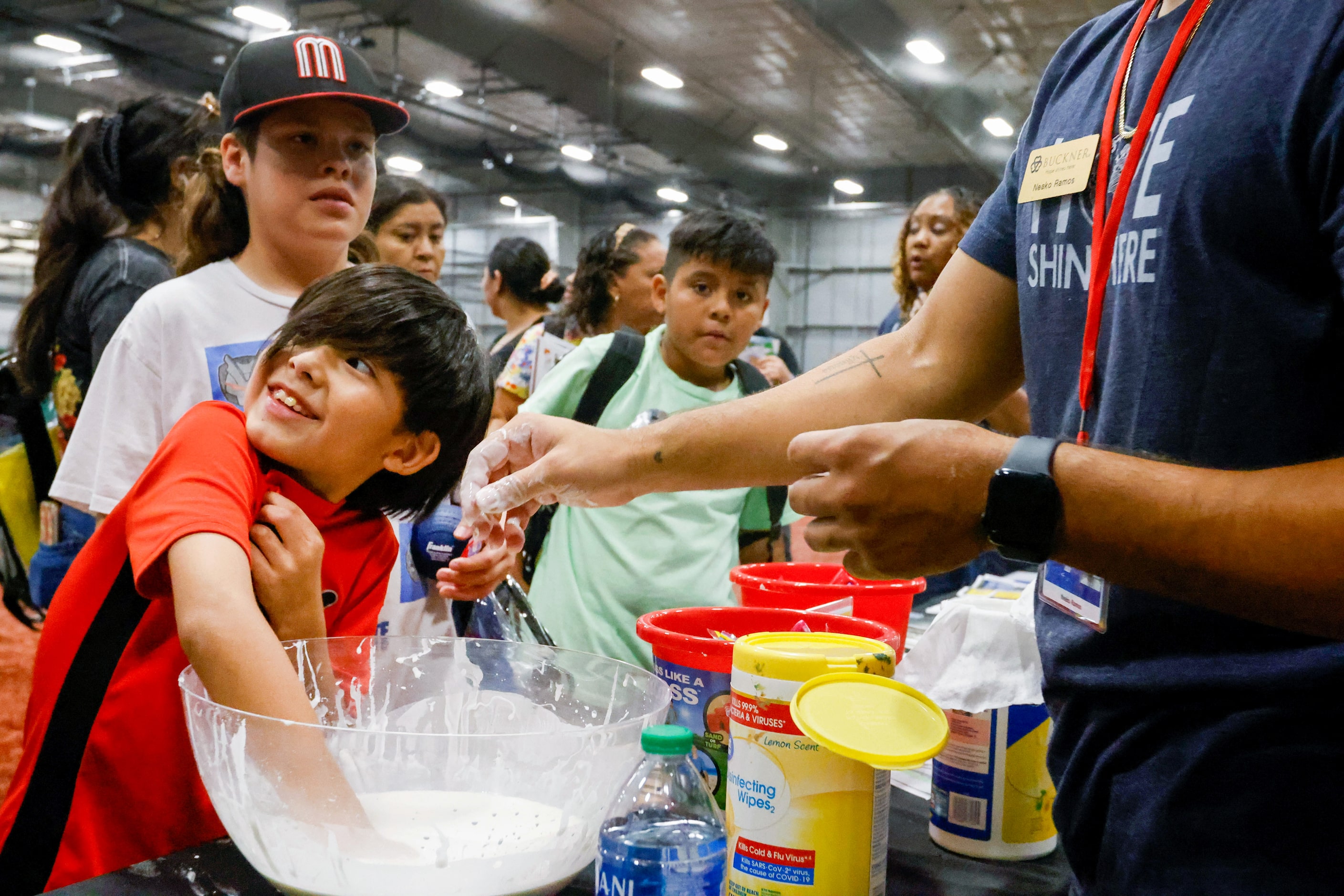 Adam Muniz (front), 9, dips his hand into a bowl of slime brought by Buckner to the...