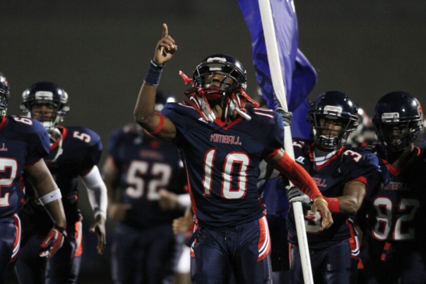 Kimball running back Brandon Hines (10) gestures upward as he leads his team onto the field...