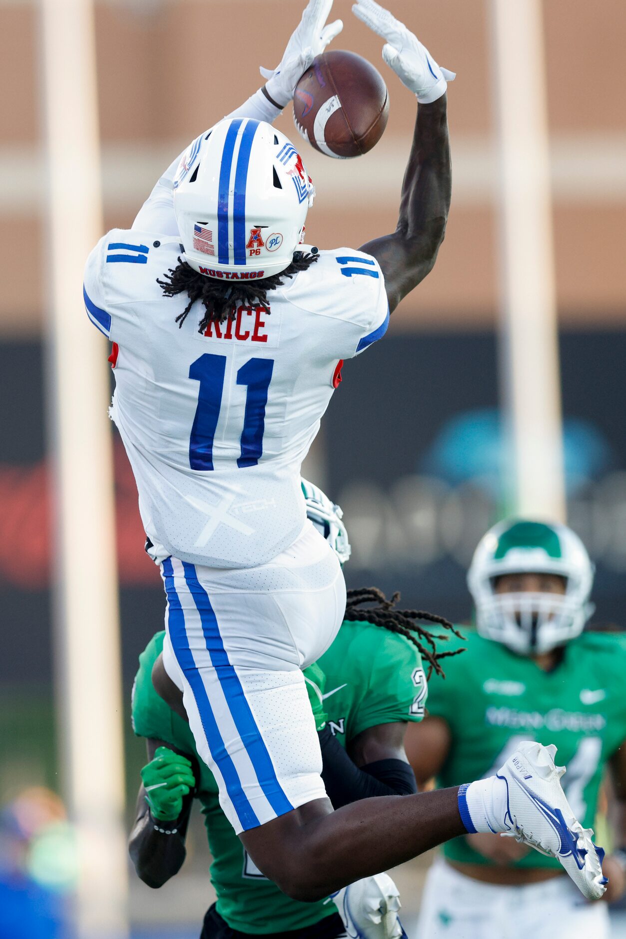 SMU wide receiver Rashee Rice (11) catches a pass over UNT defensive back DeShawn Gaddie (2)...