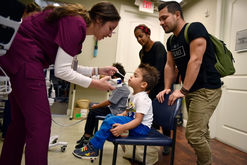 Nursing student Stephanie Beaton (left) checks the temperature of Matias Bonilla, 3, while...