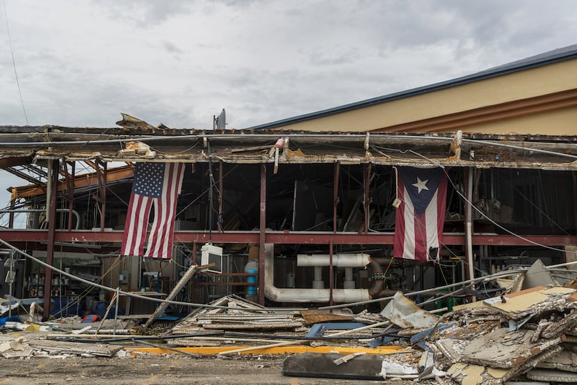American and Puerto Rican flags hang from a church heavily damaged by Hurricane Maria in...