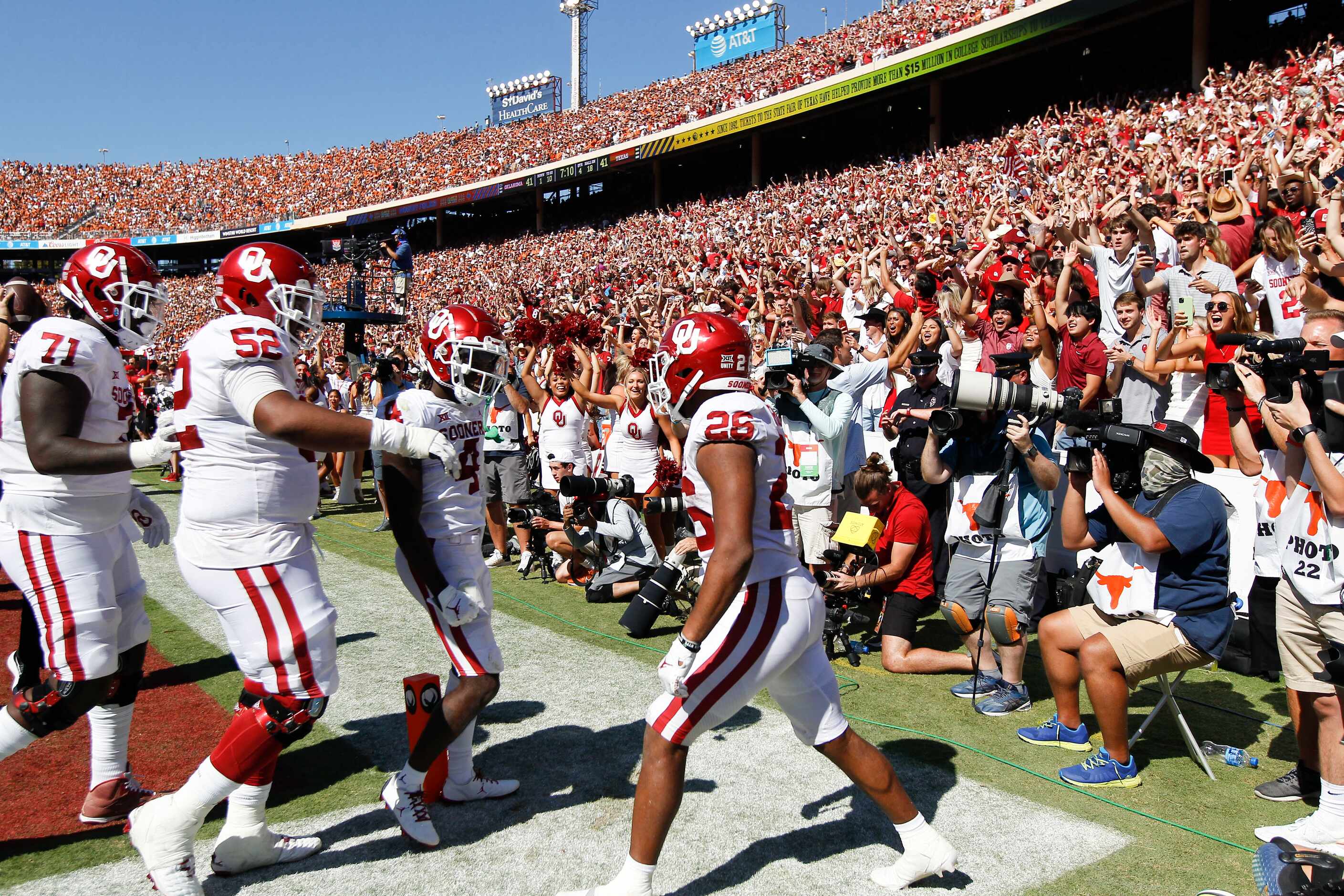 Oklahoma running back Kennedy Brooks (26) is congratulated by teammates after scoring a...