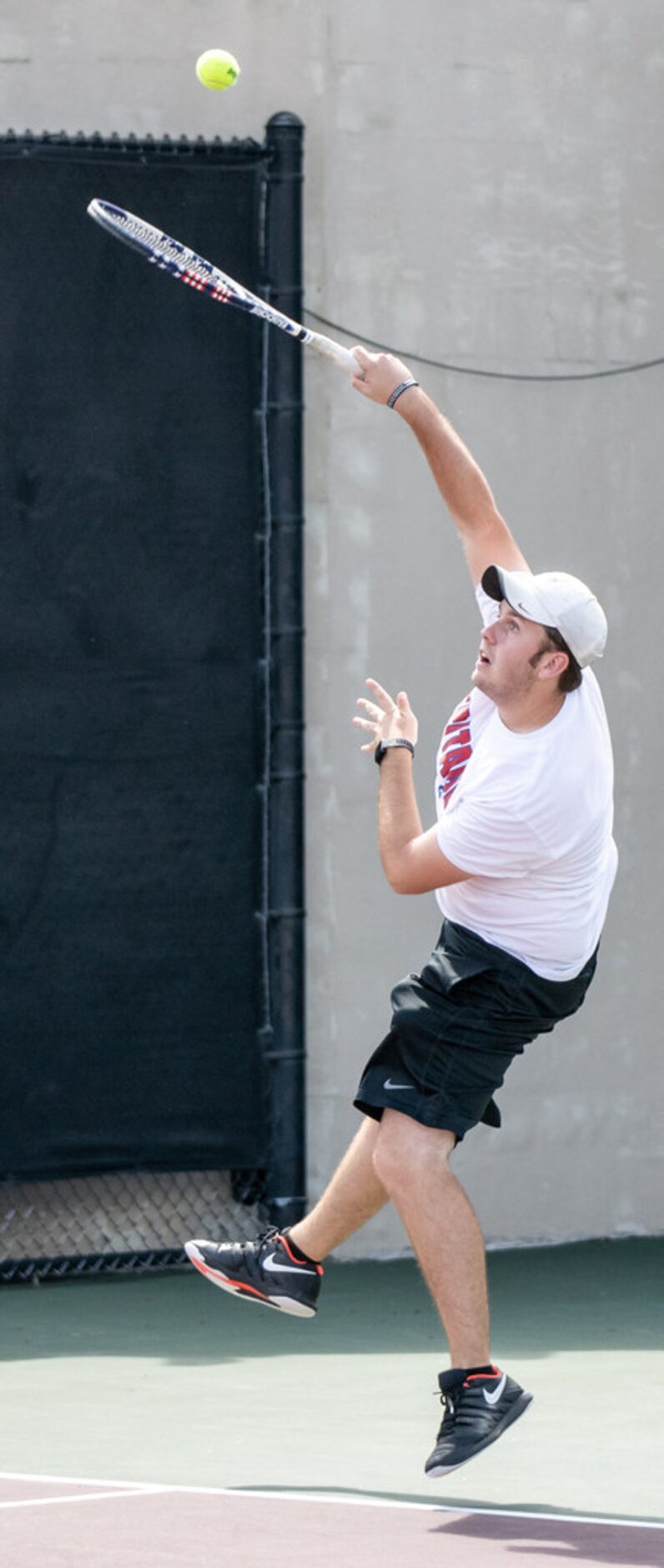 Midlothian Heritage's Joshua Windham serves the ball in a doubles match with teammate Gabe...