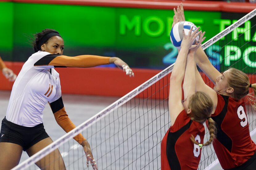 Texas' Chiaka Ogbogu (11) goes for a kill against the block of Nebraska's Kadie Rolfzen (6)...