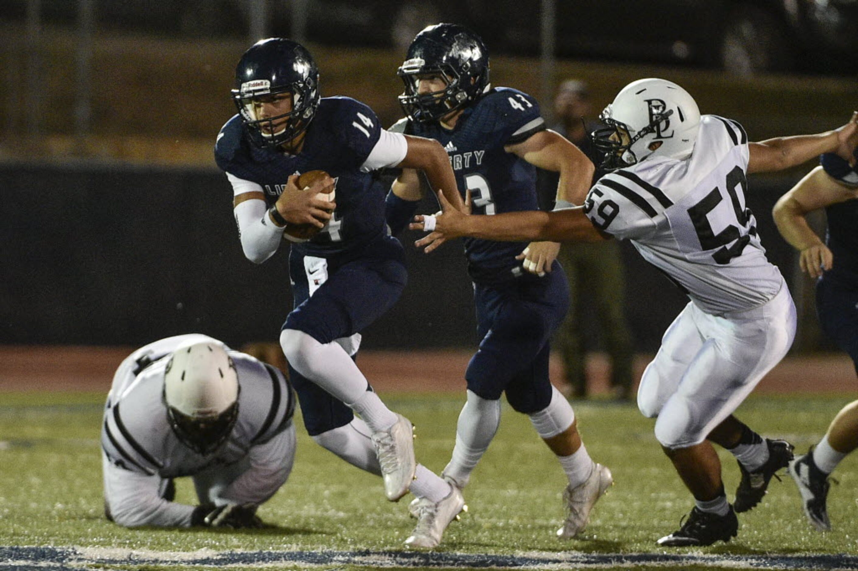 Liberty quarterback Nick Starkel (14) scrambles during a high school football game at...