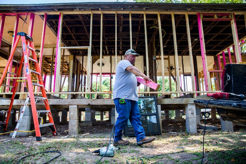 Ricky Villanueva works on his house that had severe flood damage on Oct. 11, 2017, on...