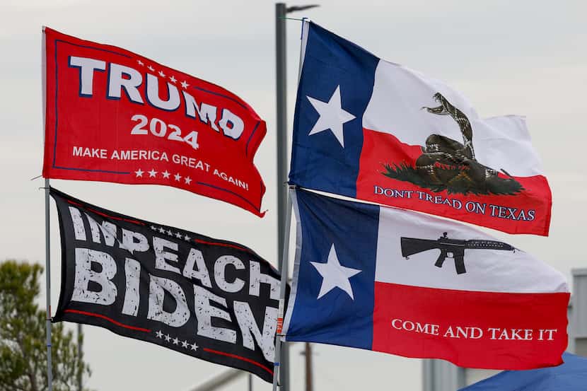 An “Impeach Biden” flag flew alongside a “Trump 2024” flag as supporters of former President...