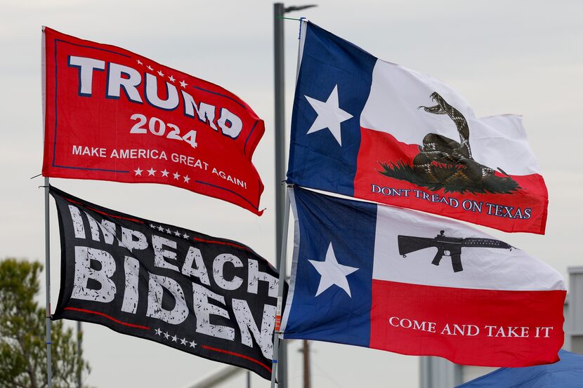 An “Impeach Biden” flag flew alongside a “Trump 2024” flag as supporters of former President...