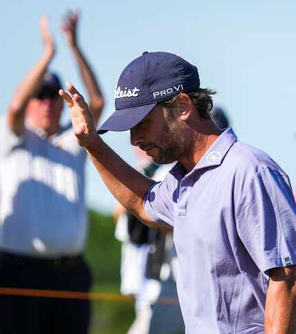 Spencer Levin waves to the crowd after hitting a putt for birdie on the 18th hole during the...
