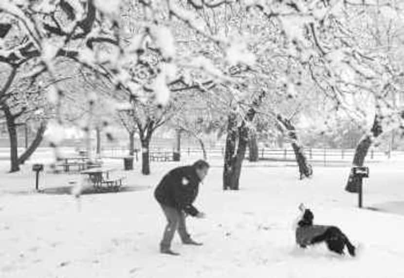 Ki Fisher of Euless spends some quality time with his pet, tossing a snowball for his...