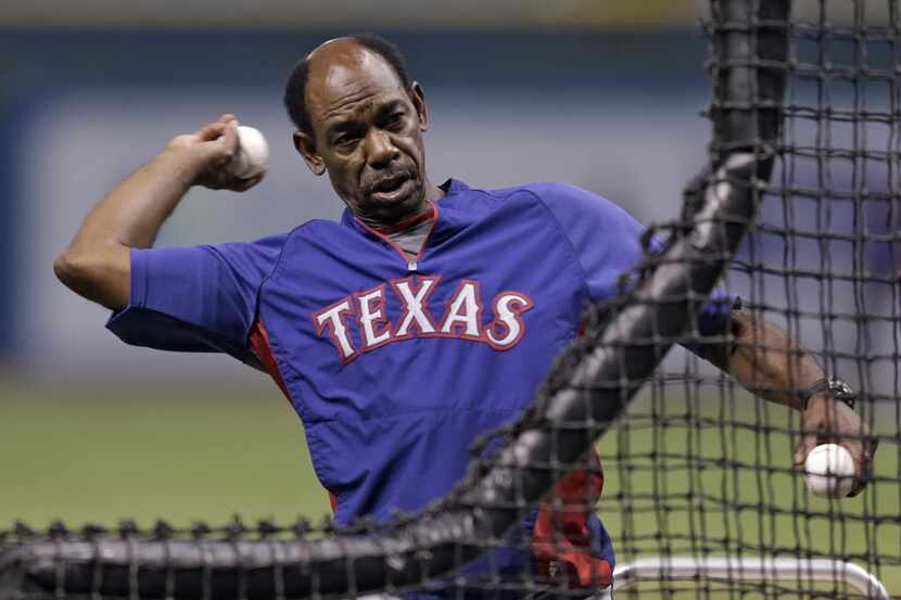 Texas Rangers manager Ron Washington throws batting practice before a baseball game against...