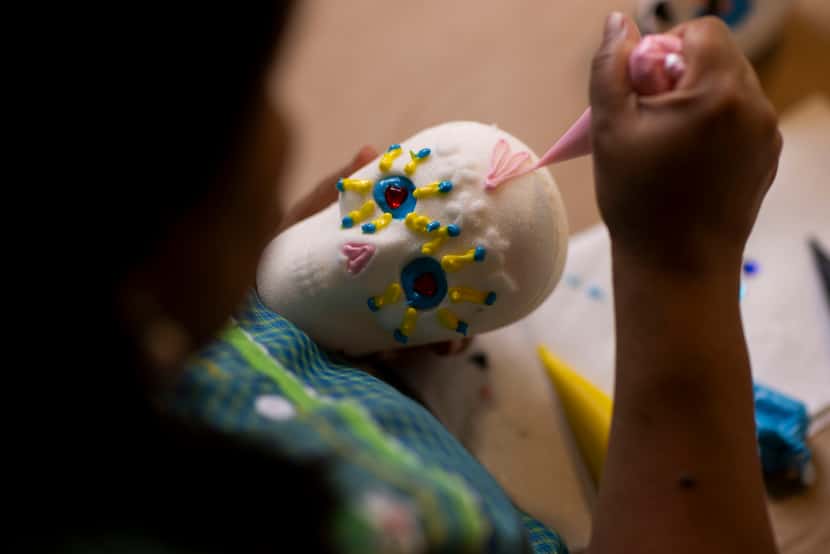 North Texas artist Maggie Wolters-Williams decorates sugar skulls at her home in Grand...