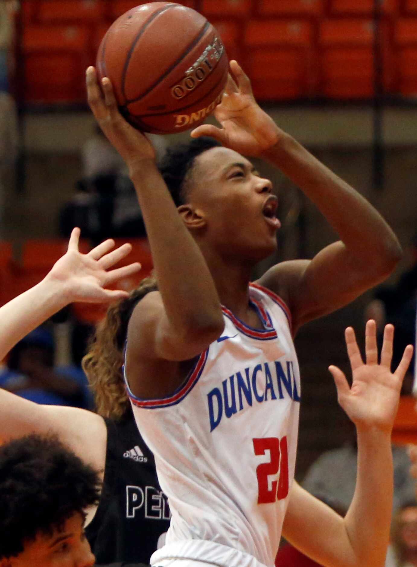Duncanville guard Evan Phelps (21) winces as he is fouled while driving the lane during...