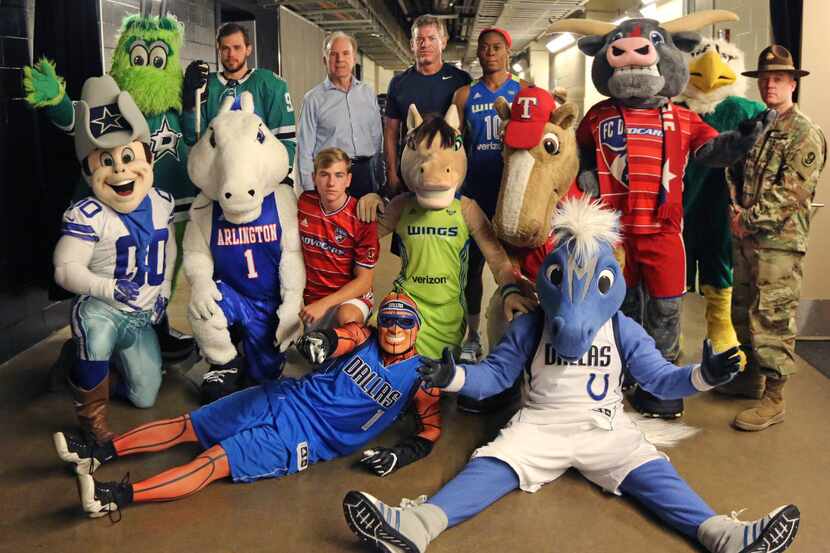 Roger Staubach and Troy Aikman posed with local sports figures and mascots after filming a...