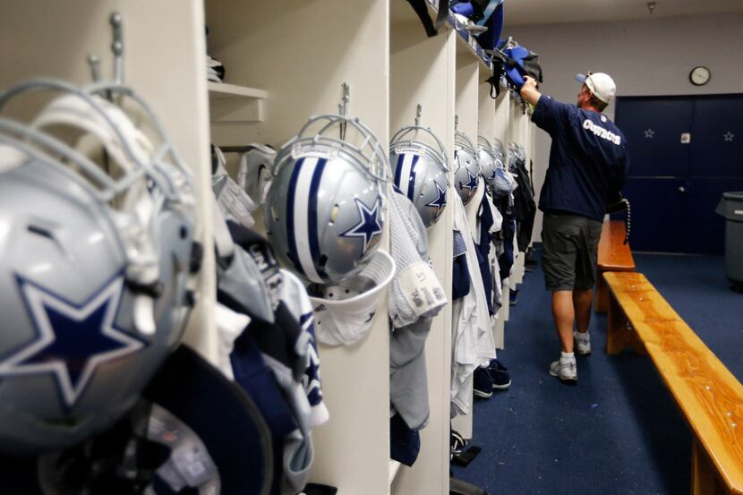 Dallas Cowboys equipment director Mike McCord checks on game bags in the locker room after...