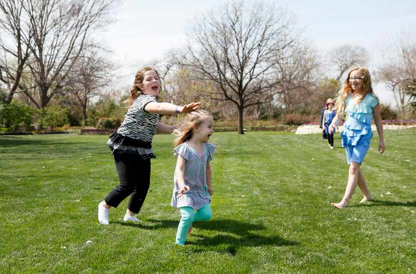 Alexis Dwyer, 8, chases Abby Kelley, 2, while Isabella Kelley, 9, watches the game of tag...
