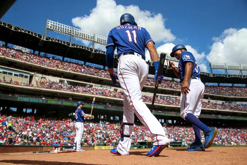 Texas Rangers first baseman Ronald Guzman (11) walks up to bat as third base coach Tony...