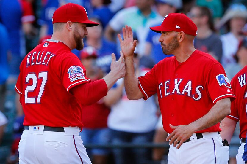 Texas Rangers relief pitcher Shawn Kelley is congratulated by manager Chris Woodward after...