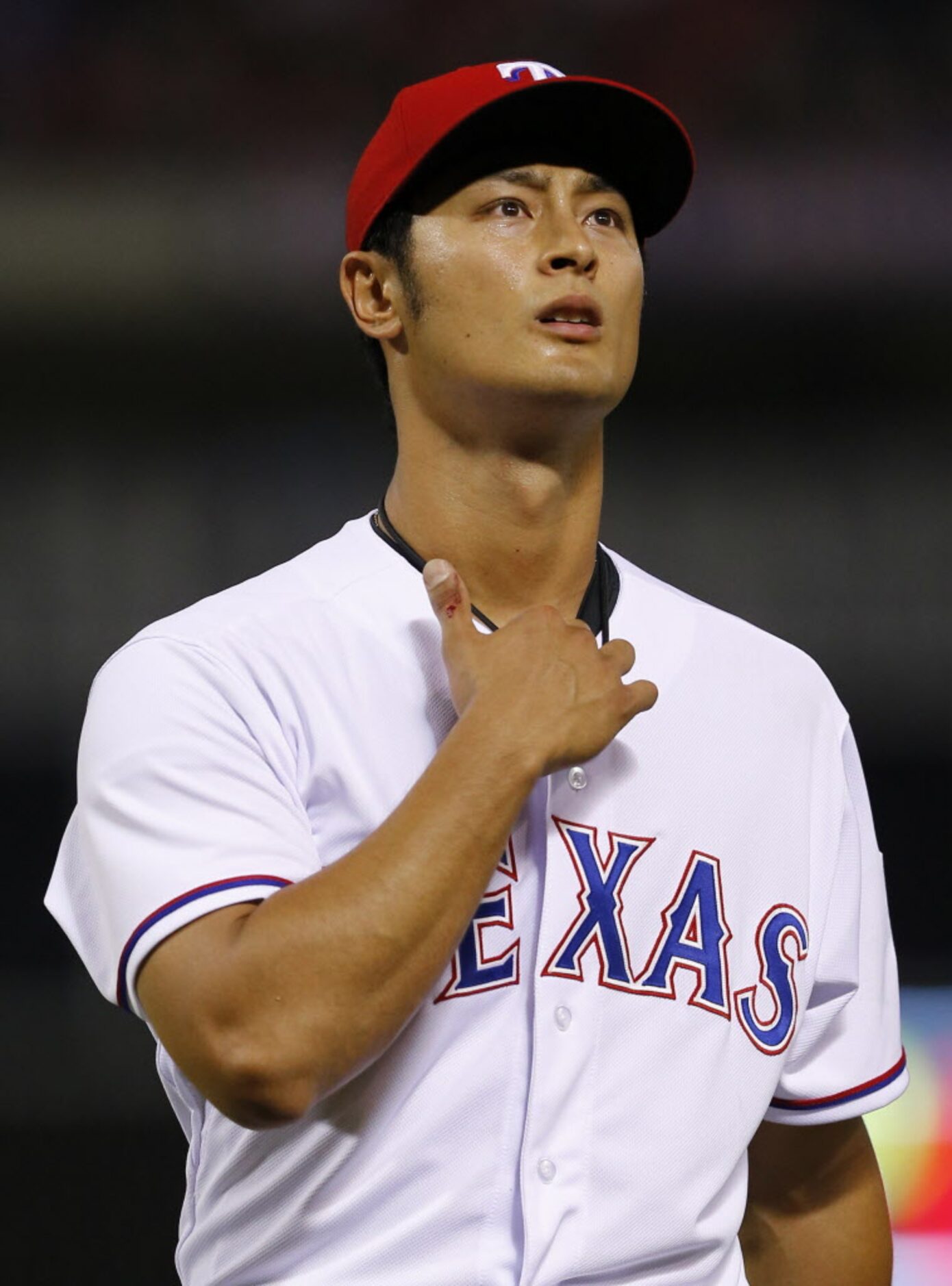 Texas Rangers starting pitcher Yu Darvish's pitching thumb bleeds as he walks to the dugout...