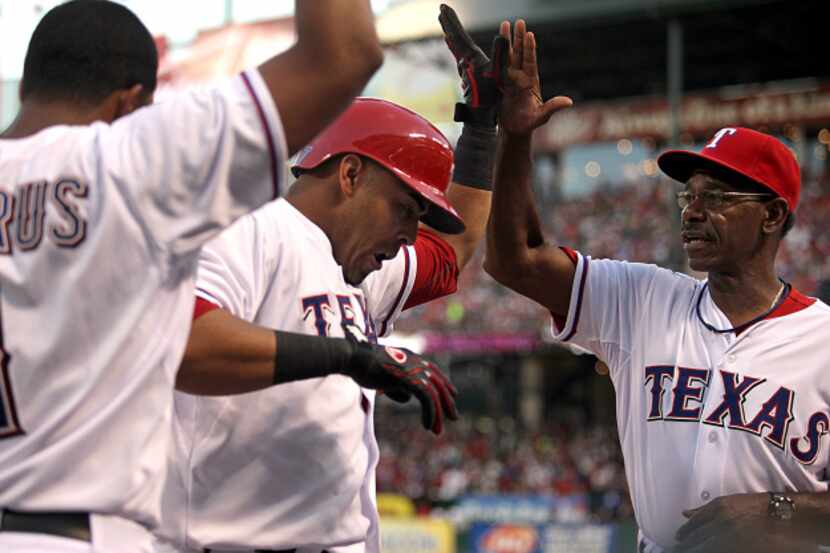 The Texas Rangers right fielder Nelson Cruz (17) is congratulated by Coach Ron Washington...