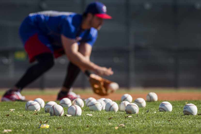 Joey Gallo fields a grounder while taking balls at third base during a spring training...
