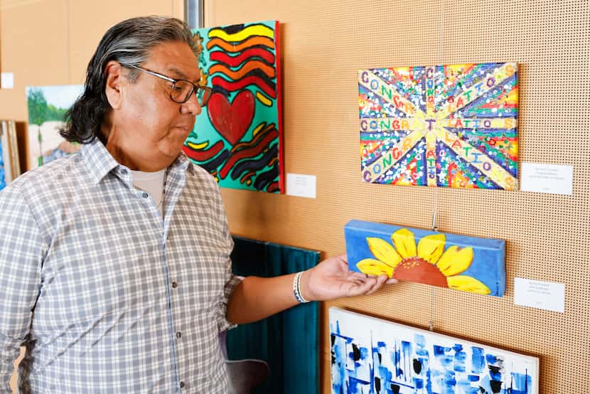 Darrell Plunkett shows his artwork, Blue Sunflower, during an art exhibition made by...