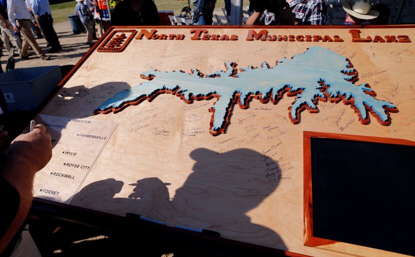 Signatures were put on a wooden board with a carved out replica of the future North Texas...