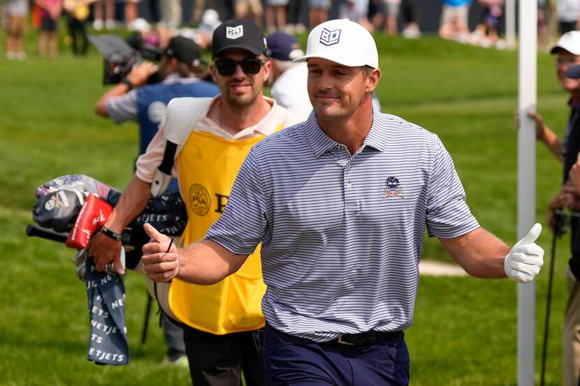Bryson DeChambeau greets fans on the sixth hole during the final round of the PGA...