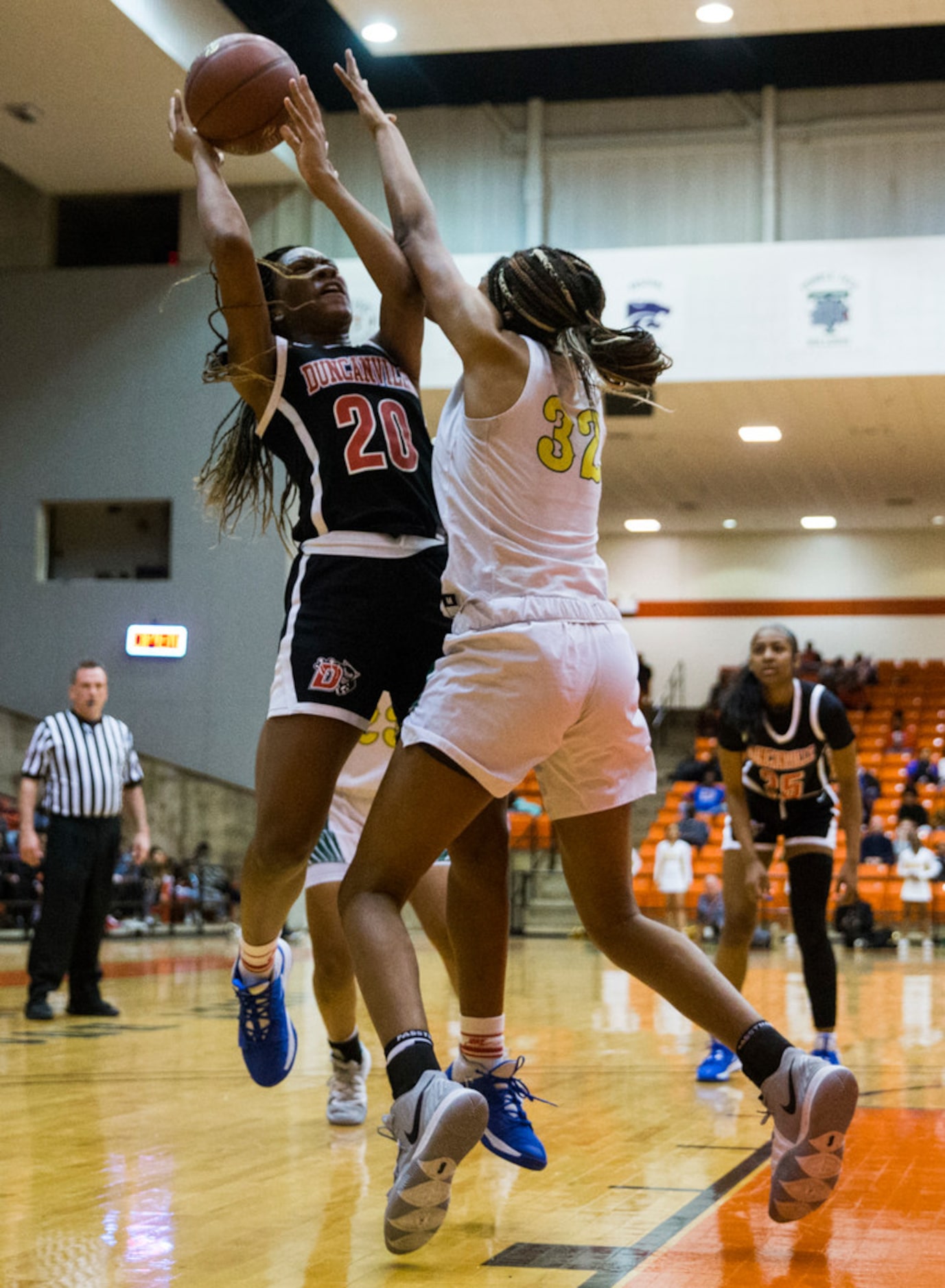 Duncanville's Anaya Bernard (20) goes up for a shot while DeSoto's Tina Herron (32) during...