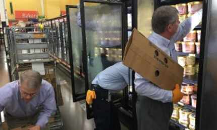  A Blue Bell delivery team unloads cartons of Butter Pecan, Dutch Chocolate, The Great...