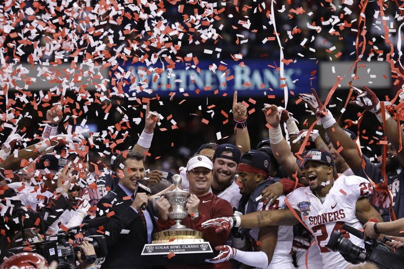 Oklahoma head coach Bob Stoops holds the Sugar Bowl trophy with his team after defeating...