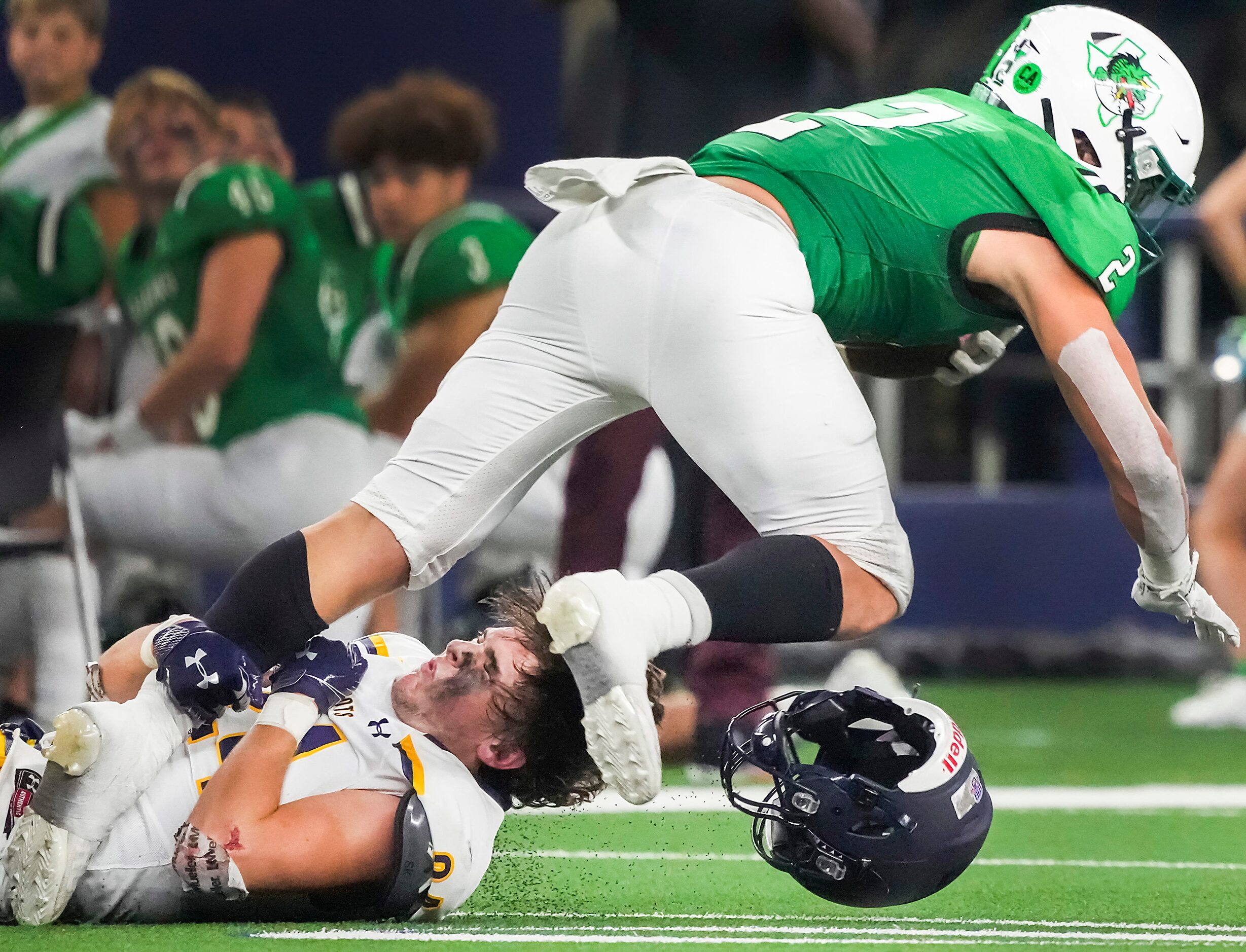 Highland Park defensive back Preston Taylor (24) has his helmet knocked off as he brings...