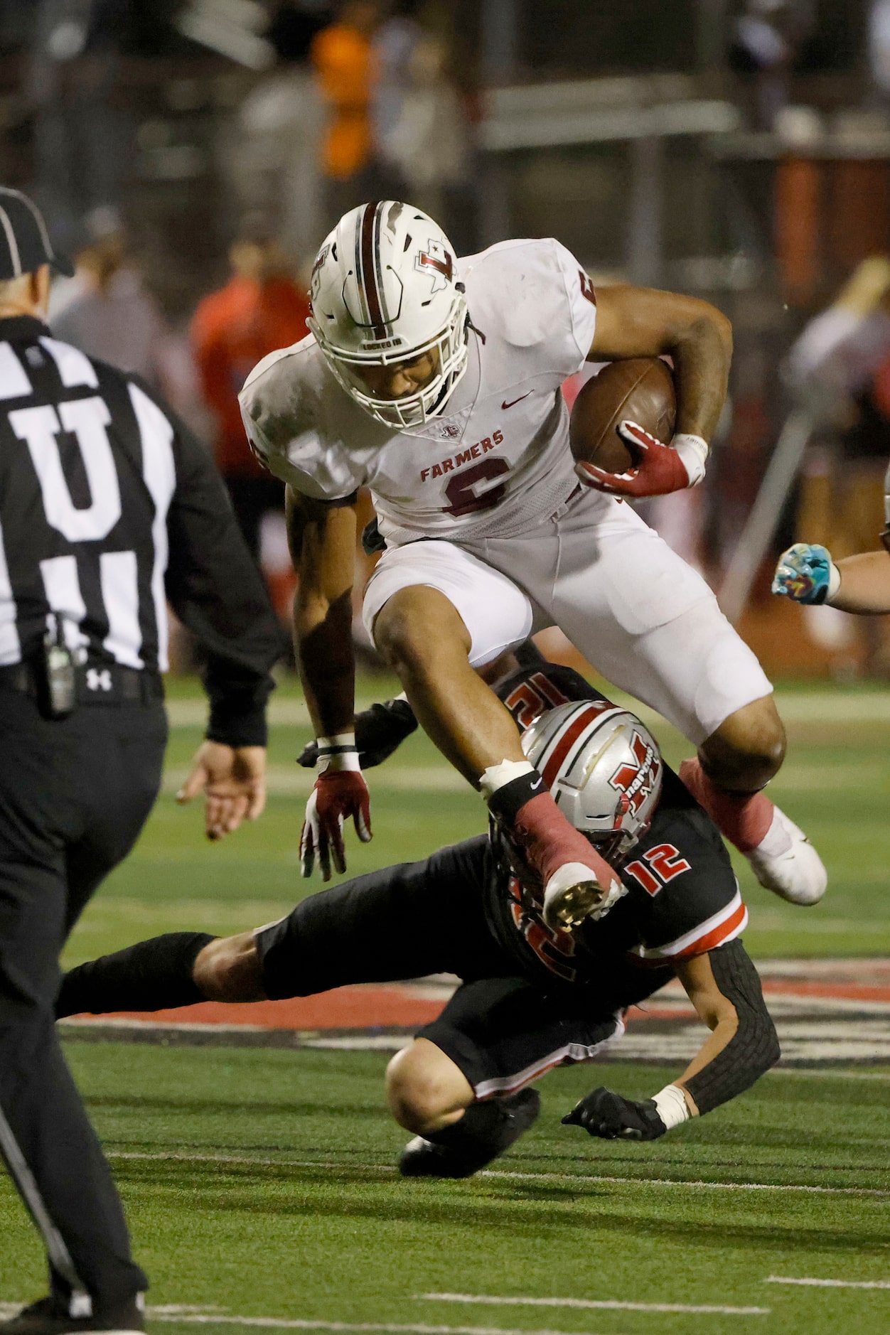 Lewisville’s Damien Martinez (6) tries to leap over Flower Mound Marcus defender Zane Benson...