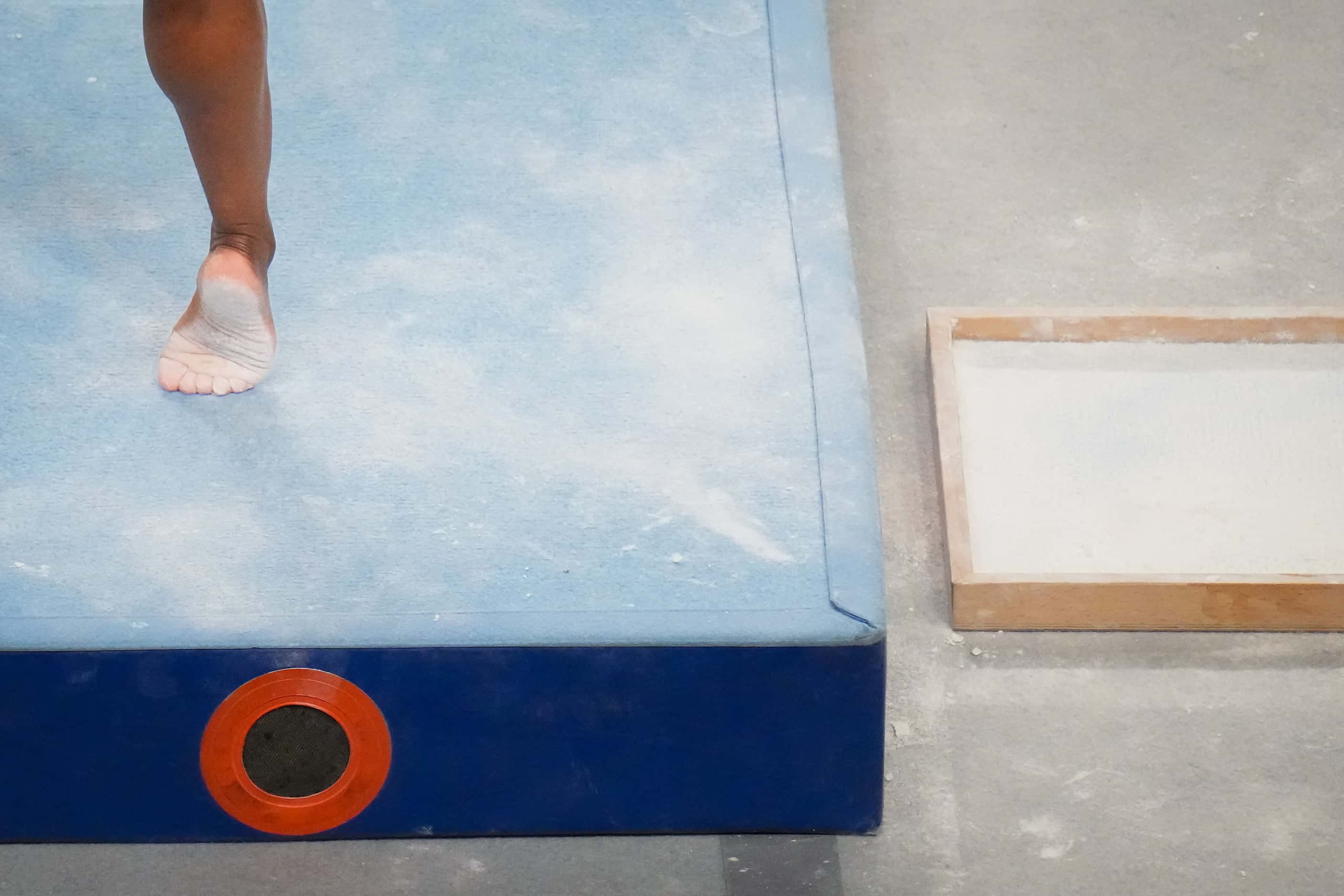 Simone Biles steps out of chalk box as she prepares to compete on the balance beam during...