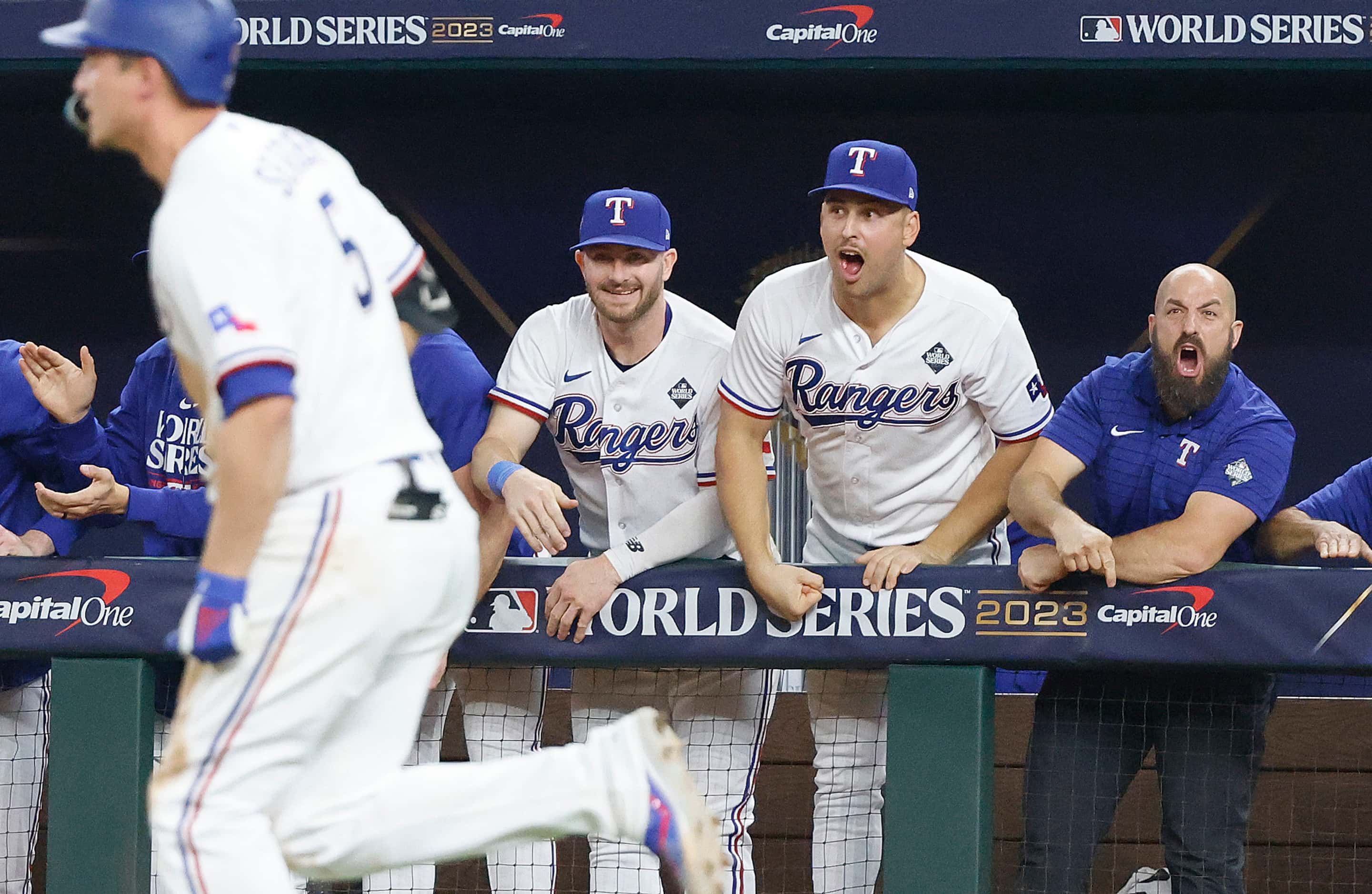 The Texas Rangers bench celebrates after Corey Seager hit a two-run home run to tie the game...