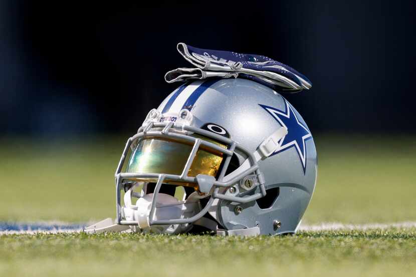 A Dallas Cowboys helmet rests on the practice field at The Star in Frisco, Texas, Thursday,...