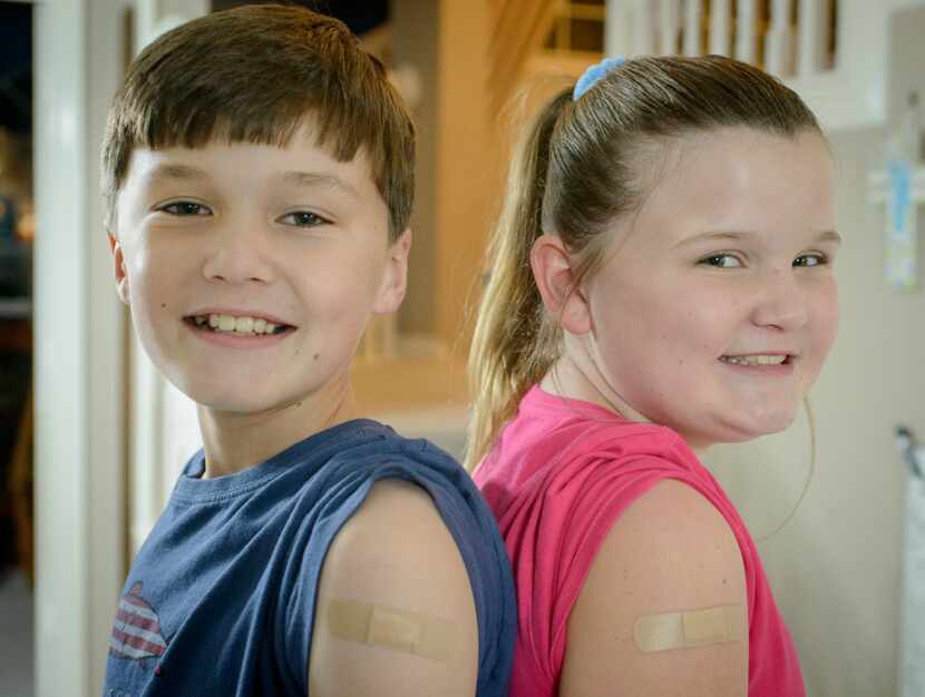 Stephen and Rachel Howe show off their COVID-19 vaccination band-aids at their Coppell home...