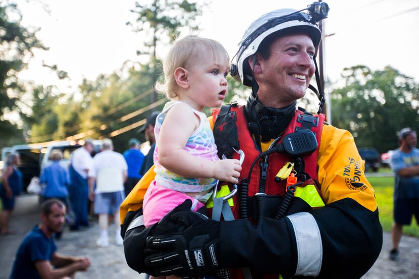Firefighter Patrick Husic of a rescue task force from Tampa, Florida holds Mayson Andersen,...