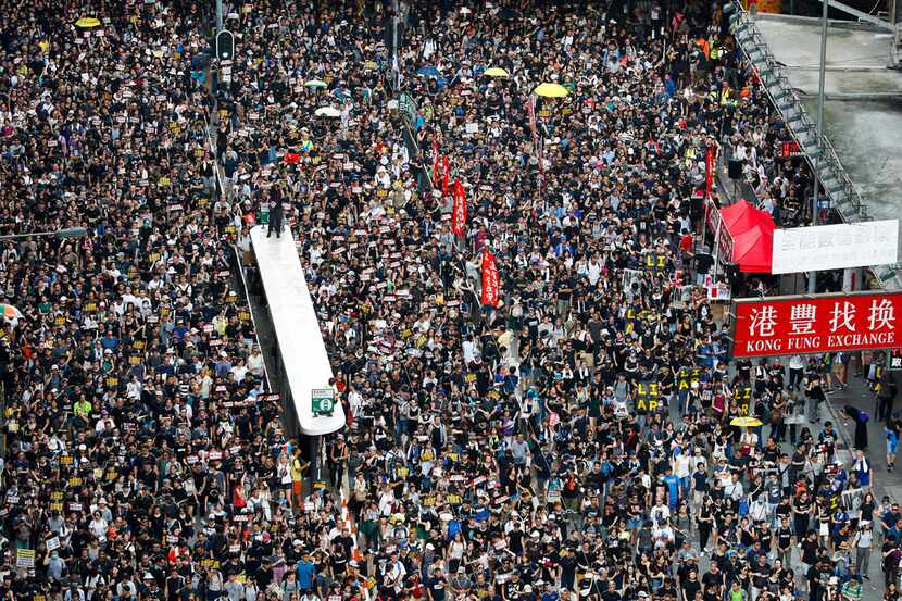 Protesters take part in a march on a street in Hong Kong. Hong Kong's protest movement has...
