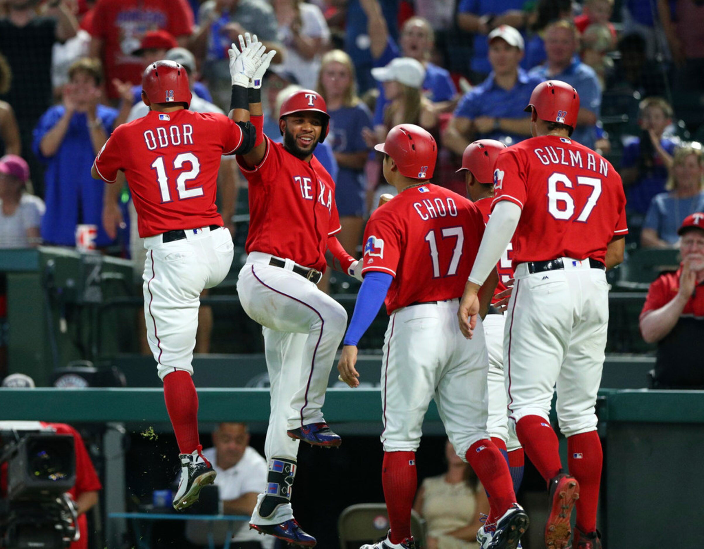 Texas Rangers' Rougned Odor (12) high-fives Elvis Andrus (1) after hitting a grand slam that...