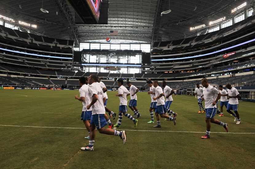 Members of the Honduran national team jog during a practice session at Cowboys Stadium in...