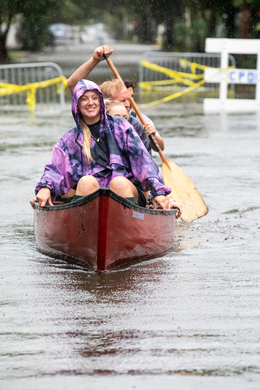 Ellie Combs, from Charleston, S.C., rides in a canoe down Ashley Ave in Charleston as...