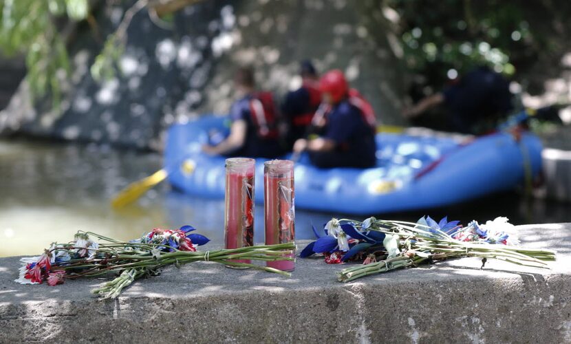 Flowers and candles were placed on a bridge at Stonebridge Drive on Turtle Creek for a...