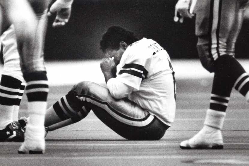 Kicker Luis Zendejas of the Dallas Cowboys sits on the ground and shakes out the cobwebs...