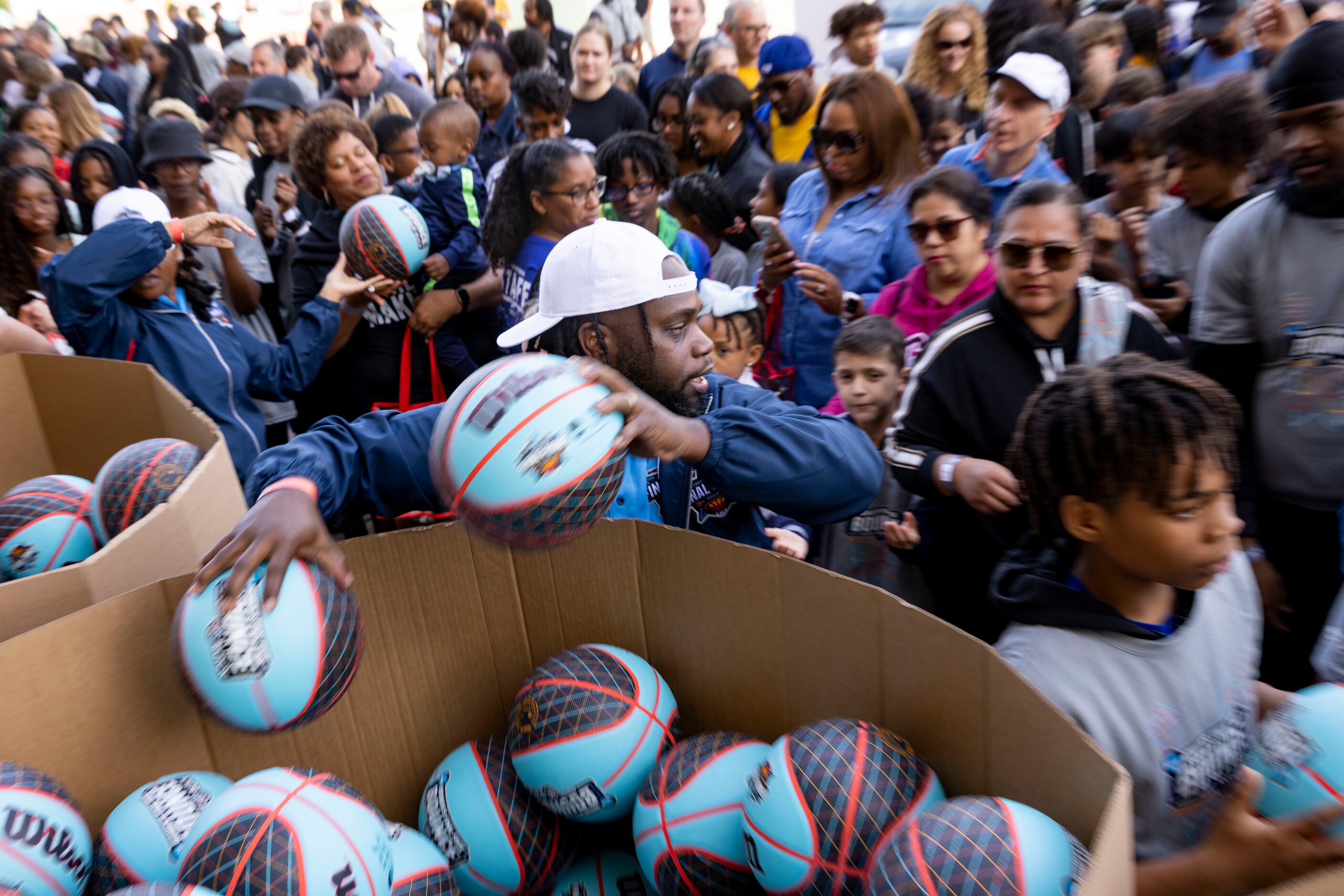 Volunteer Lance Greene hands out basketballs before people dribble their way from City Hall...