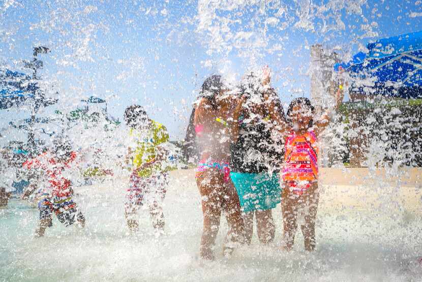 Children played in a cascade of water at the Frog Pond Water Park at Farmers Branch Aquatics...