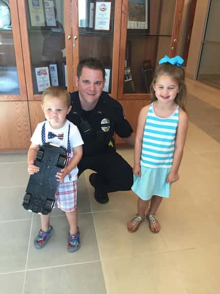 Hudson Williams, 3, and his sister Reagan, 5, pose with a Frisco police officer Robert...