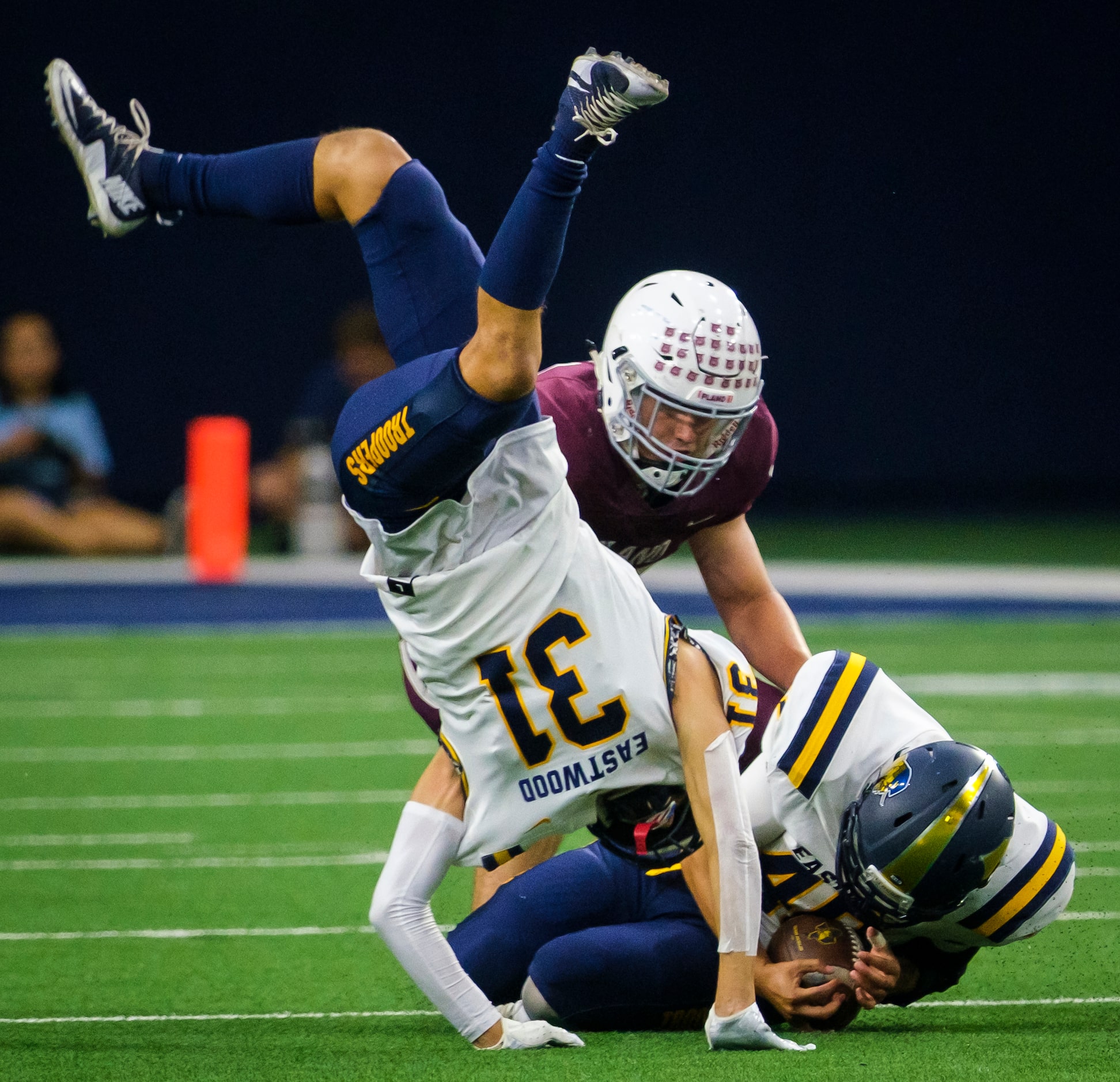 El Paso Eastwood defensive back Nathan Carranza (31) takes a tumble as teammate Kaleb Ibarra...