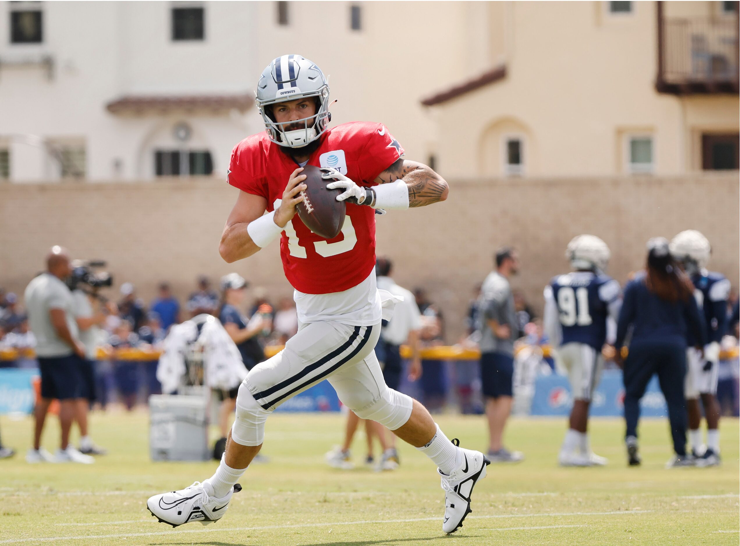 Dallas Cowboys quarterback Will Grier (15) rolls out during training camp practice passing...