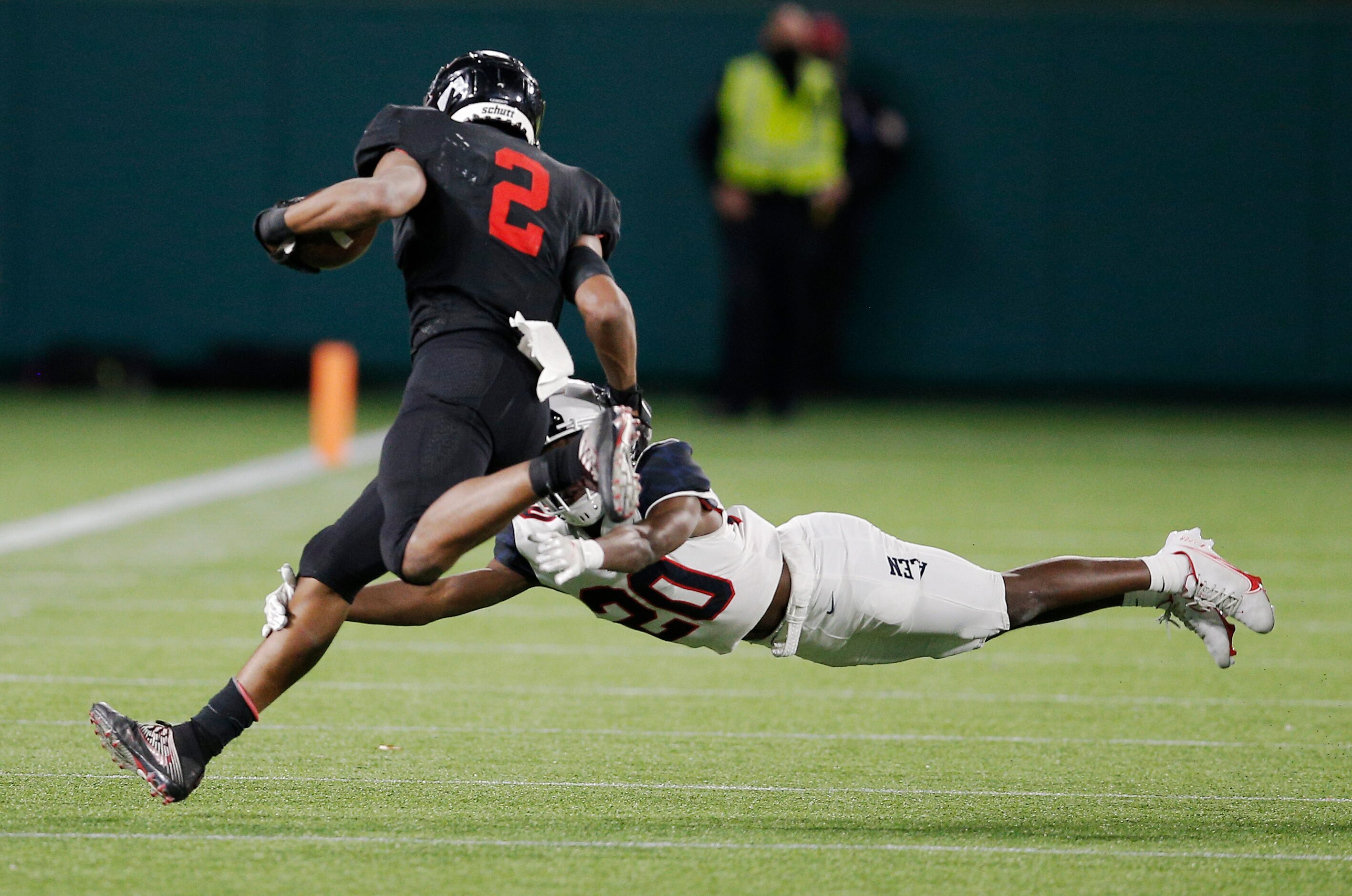 Euless Trinity junior running back Ollie Gordon (2) attempts to avoid Allen junior defensive...